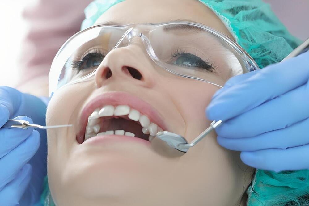 dentista examinar dientes paciente gafas protectoras gorro herramientas dentales